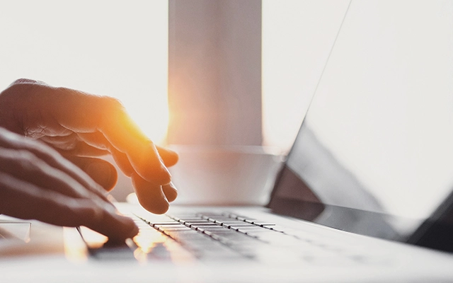 IT developer typing on a laptop